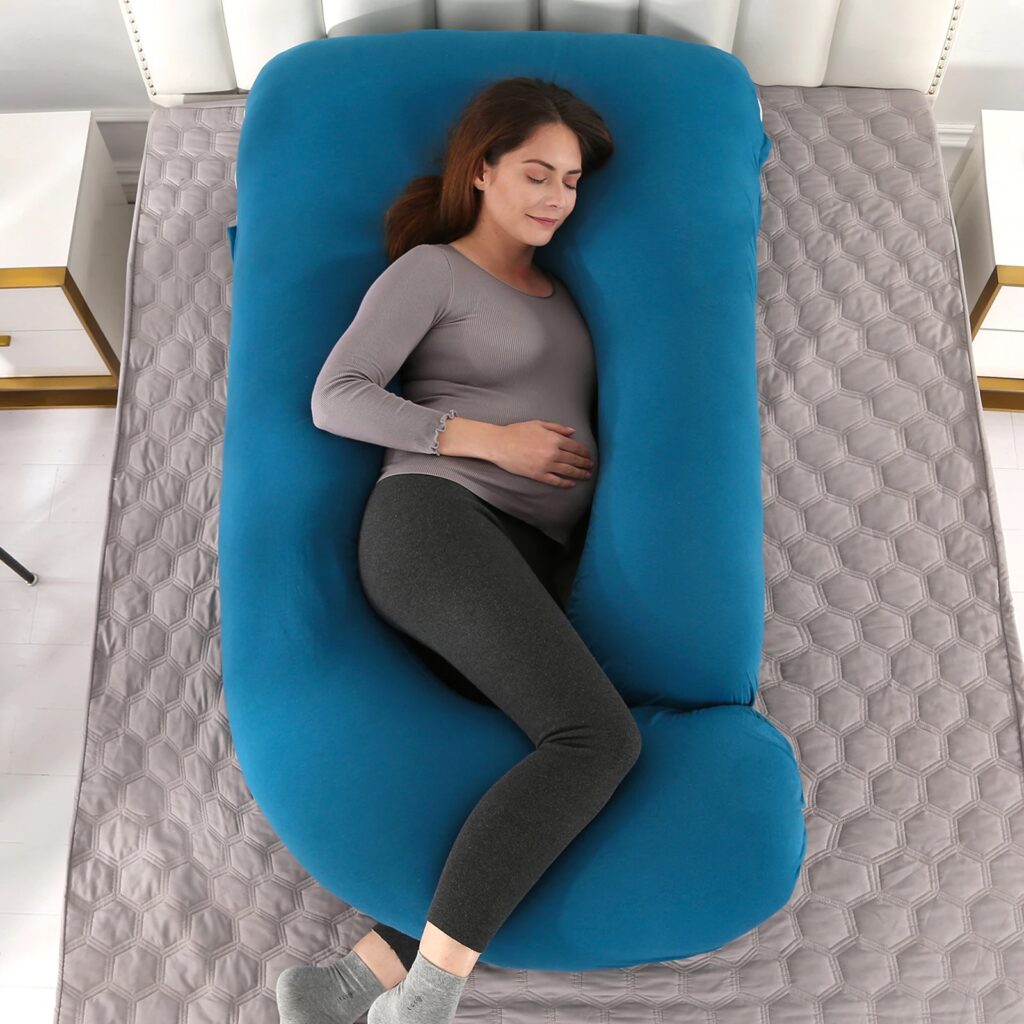 how to use a pregnancy pillow, woman lying down with a full body pregnancy pillow